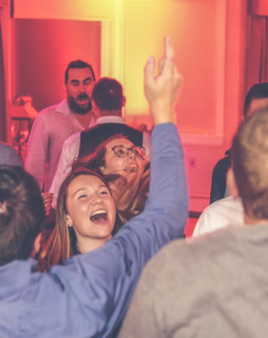 Guests dancing at a party with colorful lighting