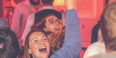 Guests dancing at a party with colorful lighting