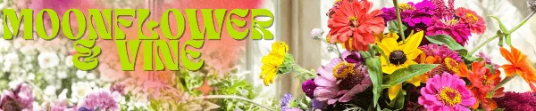 A colorful floral arrangement featuring pink and red zinnias, a yellow sunflower, and green foliage.