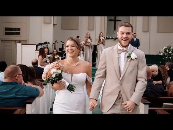 A bride and groom walking down a church aisle during a wedding ceremony.