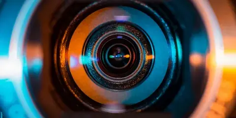 Close-up view of a camera lens with blue and orange reflections