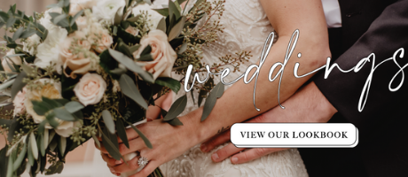 A bride holding a bouquet of white and cream roses with greenery, with the word 'weddings' overlaid.