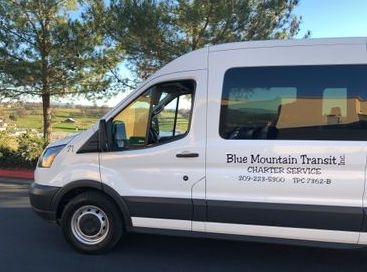White Blue Mountain Transit shuttle van parked outdoors