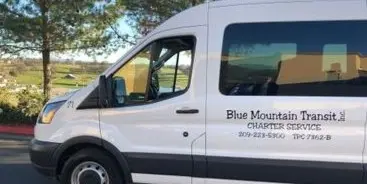 White Blue Mountain Transit shuttle van parked outdoors