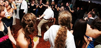 Guests dancing on a dance floor at a wedding or party event.