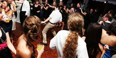 Guests dancing on a dance floor at a wedding or party event.