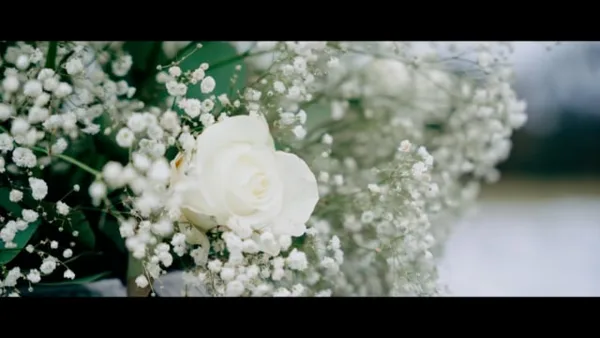 Close-up of a white rose and baby's breath wedding bouquet.