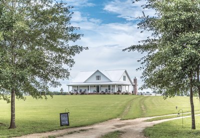 Exterior view of the Rosie Creek Farms white barn and grounds in Panama City, Florida.