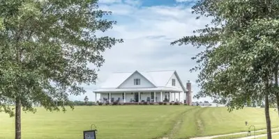 Exterior view of the Rosie Creek Farms white barn and grounds in Panama City, Florida.