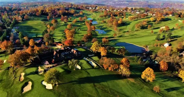 Aerial view of St. Clair Country Club showing the clubhouse, golf course, and surrounding landscape in autumn.
