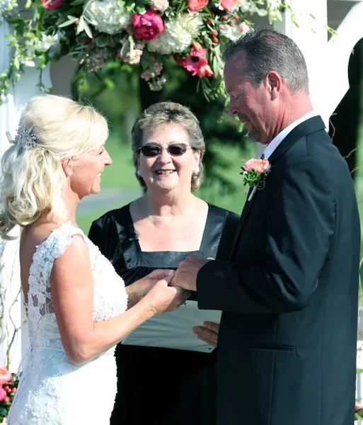 A wedding officiant presiding over a couple exchanging rings during a ceremony.