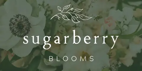 A close-up photograph of a lush floral arrangement featuring white peonies, soft pink roses, and greenery, with the Sugarberry Blooms logo overlaid.