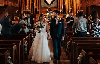 A bride and groom walking down the aisle of a church during a wedding ceremony.