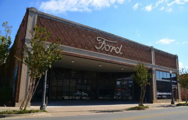 Exterior view of a historic brick building with a large 'Ford' sign on the facade, serving as the Brick Room Events venue.