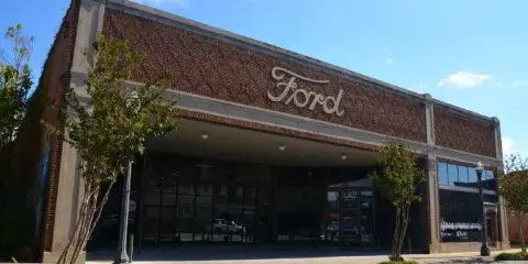 Exterior view of a historic brick building with a large 'Ford' sign on the facade, serving as the Brick Room Events venue.