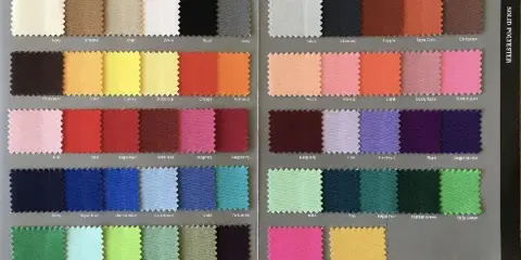 A fabric swatch book displaying a wide variety of solid polyester linen colors and textures.
