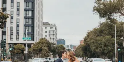A bride and groom sharing a kiss in the middle of a city street.