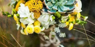 A floral bouquet featuring yellow craspedia, white flowers, and succulents, labeled with the text 'Weddings'.