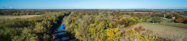 Aerial view of a scenic river winding through a forested landscape with autumn foliage.