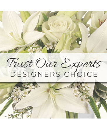A white floral arrangement featuring lilies and roses with the text 'Trust Our Experts Designers Choice'.