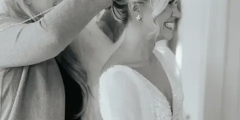 A hair and makeup artist styling a bride's hair in an elegant updo.