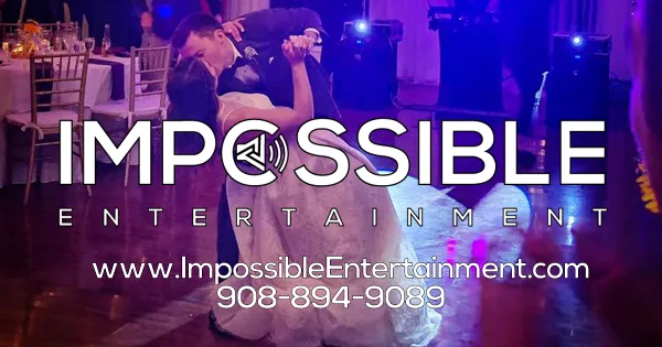 A couple dancing at a wedding reception with professional stage lighting and audio equipment visible in the background.