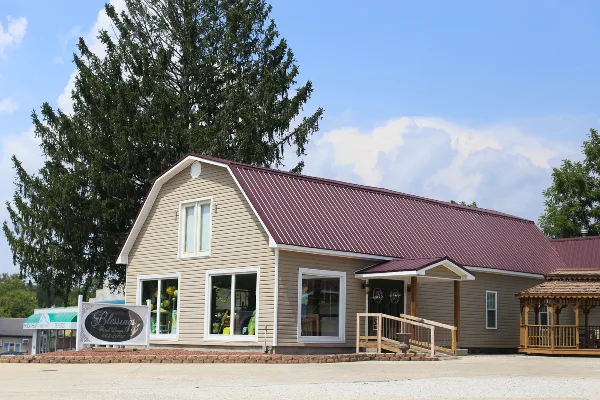 Exterior view of the Blessings Floral Design storefront building with a maroon roof and a sign in the front yard.