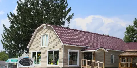 Exterior view of the Blessings Floral Design storefront building with a maroon roof and a sign in the front yard.