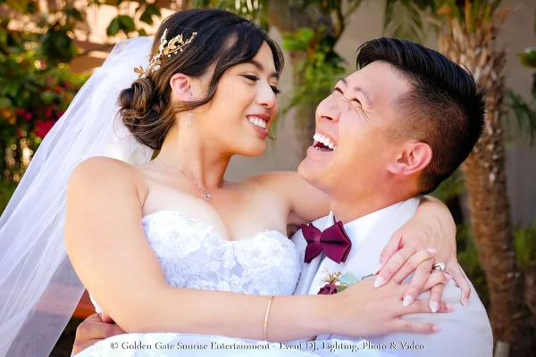 A smiling bride and groom embracing in a close-up wedding portrait.