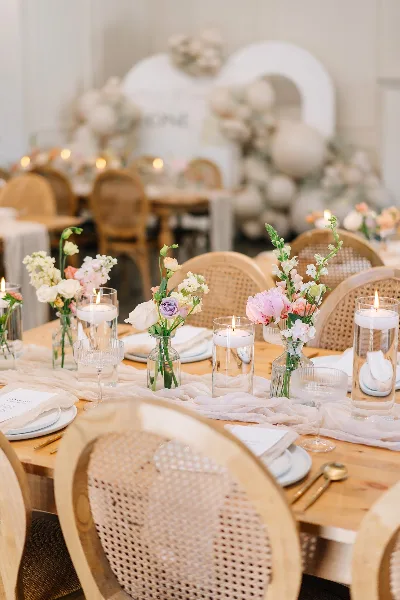 A close-up view of a styled event table with floral arrangements, candles, and table decor.