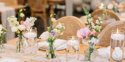 A close-up view of a styled event table with floral arrangements, candles, and table decor.