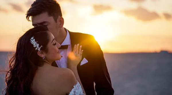 A bride and groom embracing during a sunset wedding portrait.