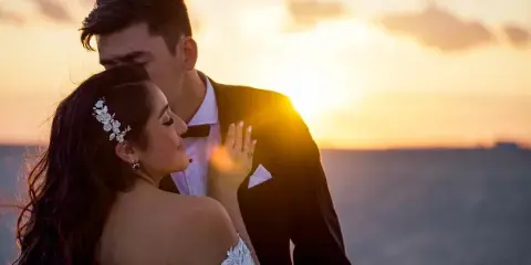 A bride and groom embracing during a sunset wedding portrait.