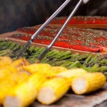Grilled corn and asparagus beside cedar-planked salmon