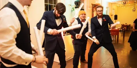 Guests dancing at a wedding reception with a DJ light fixture visible in the background.