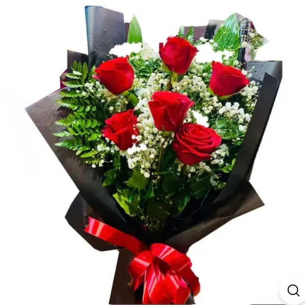 A bouquet of red roses with white filler flowers wrapped in black paper
