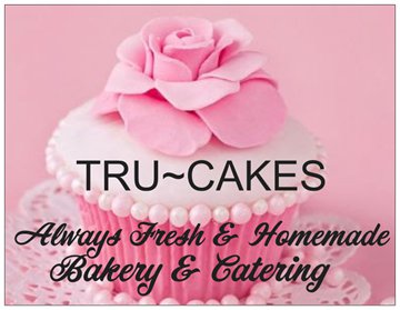 A pink cupcake topped with a large fondant rose, featuring the text 'TRU~CAKES Always Fresh & Homemade Bakery & Catering'.