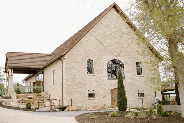 Exterior view of the Venue 1883 historic stone building with a steep roof and arched windows.