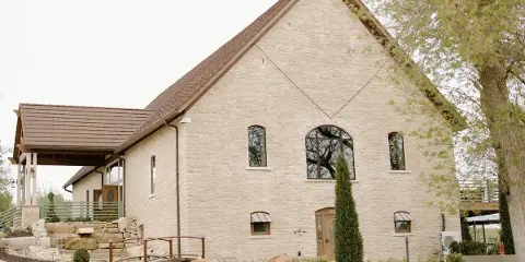 Exterior view of the Venue 1883 historic stone building with a steep roof and arched windows.