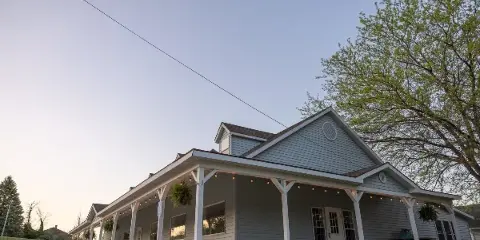 Exterior view of the Grow Benzie event center building featuring a long porch, string lights, and a gabled roof.