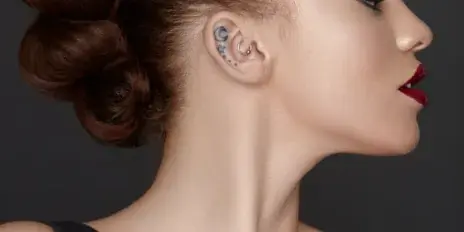 Profile portrait of a model with a styled updo and professional makeup