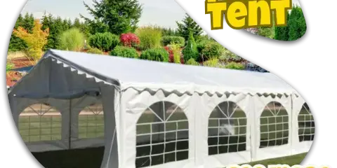 A large white event tent with arched windows set up on a lawn in front of a garden.
