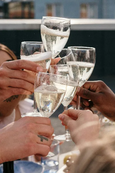 A group of hands holding champagne flutes in a celebratory toast.