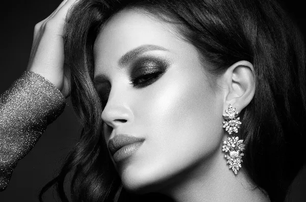 Black and white close-up portrait of a woman with professional makeup and styled hair