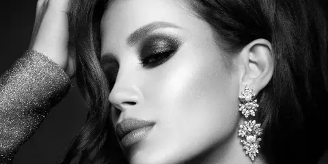 Black and white close-up portrait of a woman with professional makeup and styled hair