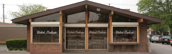 Exterior view of the Weber's Bakery brick storefront with large display windows bearing the business name.