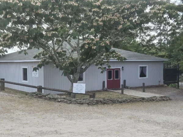 Exterior view of the South On Whiskey event venue building with a sign in the foreground.