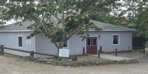 Exterior view of the South On Whiskey event venue building with a sign in the foreground.