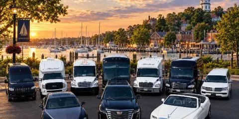 A fleet of luxury vehicles including limousines, sedans, and coaches branded with 'Blanchard' parked in front of the Annapolis waterfront at sunset.