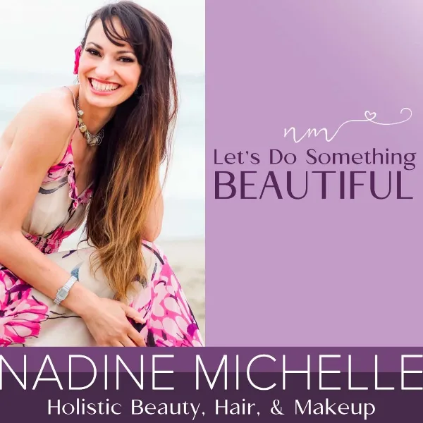 Portrait of Nadine Michelle, a hair and makeup artist, smiling with long styled hair.